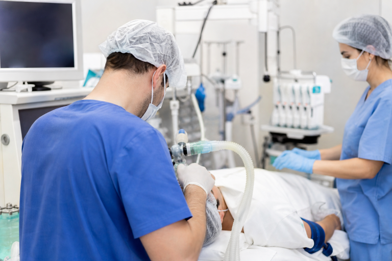 Médico anestesiologista acompanha paciente durante procedimento ambulatorial com equipamentos de monitoramento, sem textos ou logotipos visíveis